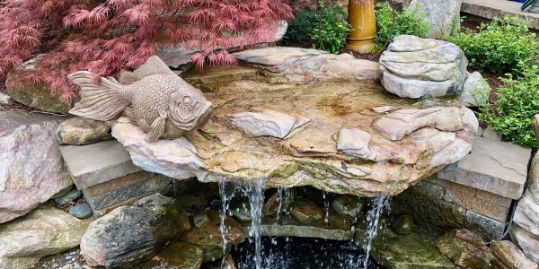 a-beautiful-landscaped-water-feature-provides-a-tr-PLUHTMX